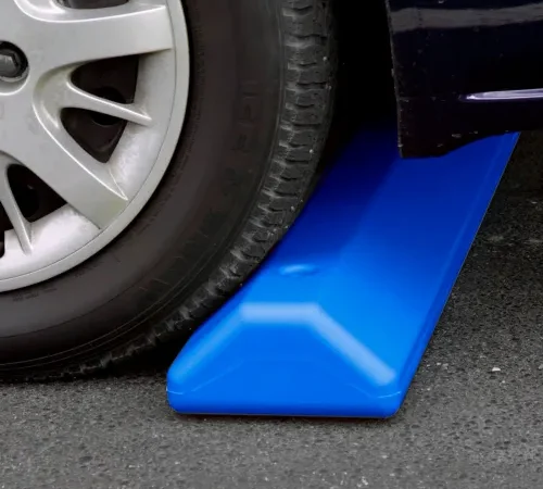 Car tire on blue wheel chock