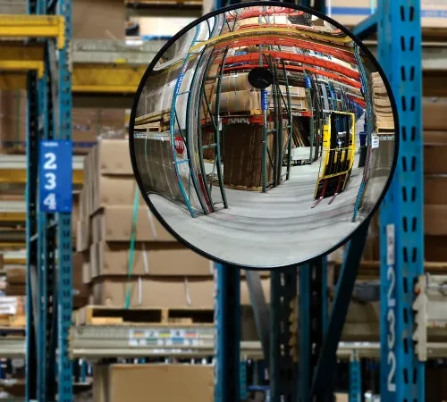 Convex safety mirror reflecting warehouse storage racks