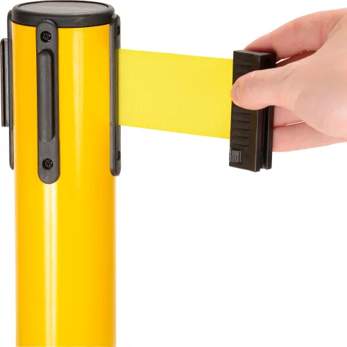 Hand pulling yellow retractable stanchion belt
