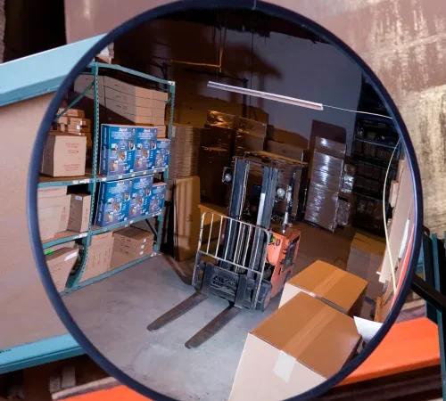 Convex mirror reflecting warehouse forklift and boxes