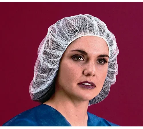 Woman wearing white bouffant cap and scrubs