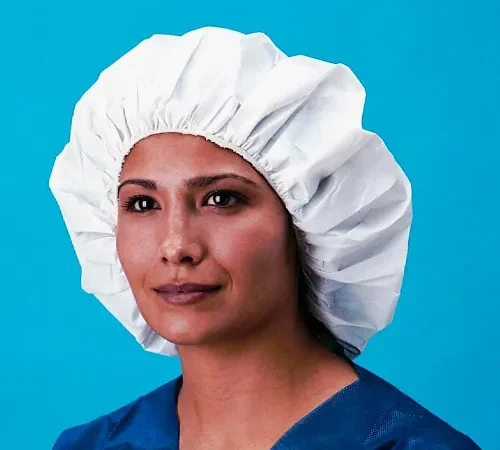 Person wearing white bouffant cap and scrubs