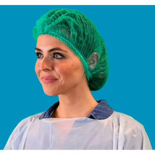Smiling woman in green surgical cap and gown