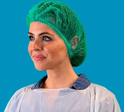 Smiling healthcare worker wearing green surgical cap