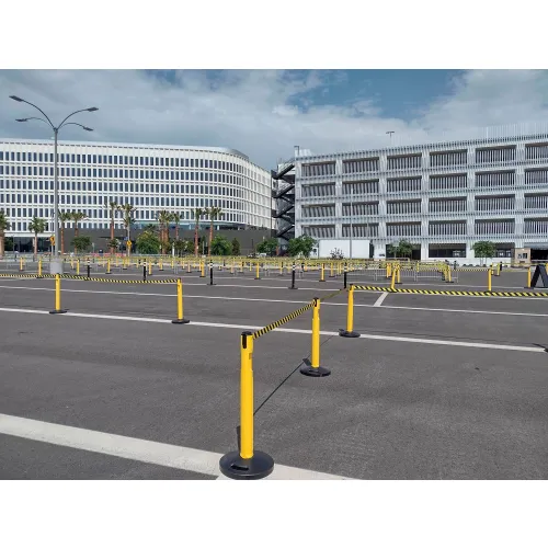 Empty parking lot with yellow stanchions and buildings