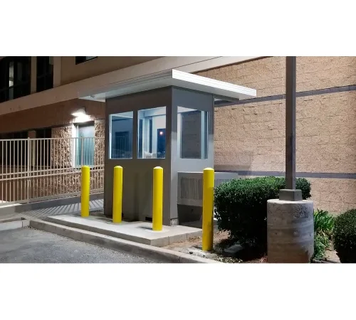 Illuminated security guard booth with yellow bollards