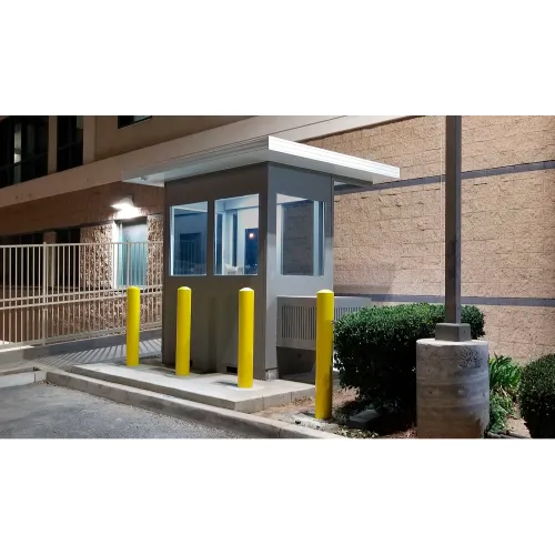 Illuminated security guard booth with yellow bollards