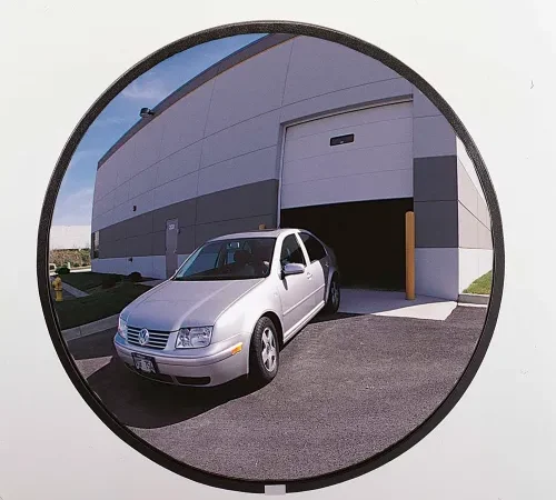 Convex mirror reflection of silver car exiting garage