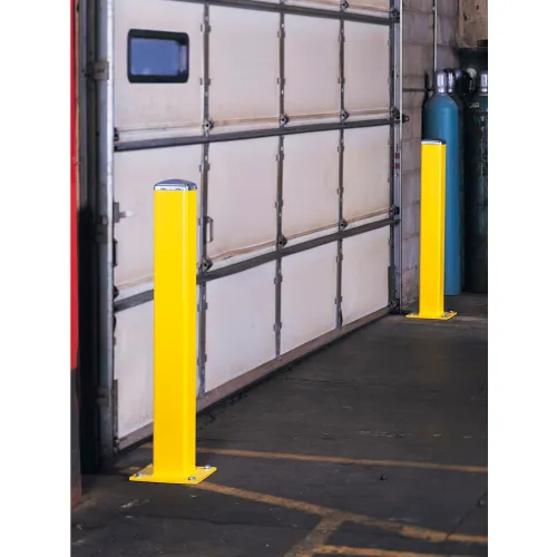 Yellow protective bollards flanking garage door