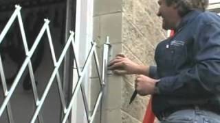 Person installing metal retractable security gate
